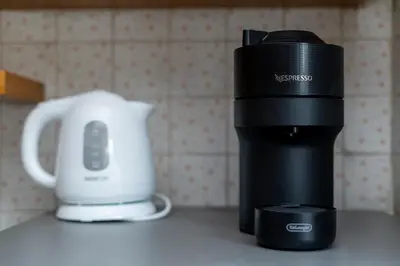 a coffee maker and a cup on a counter at Nowa Huta Charming Details Apartment by BookingHost in Kraków