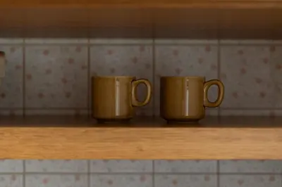 two coffee mugs sitting on a shelf in a kitchen at Nowa Huta Charming Details Apartment by BookingHost in Kraków