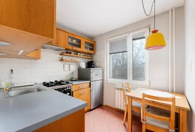 a kitchen with a sink and a table with chairs at Nowa Huta Charming Details Apartment by BookingHost in Kraków
