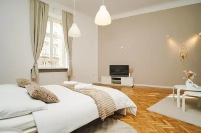 a bedroom with two beds and a flat screen tv at Old Town Sarego Apartment in Kraków