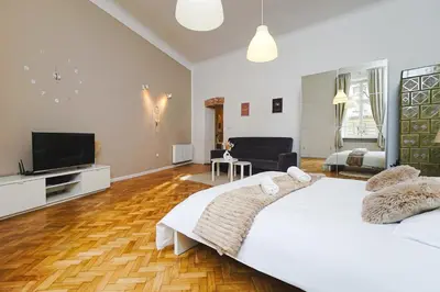 a bedroom with a large bed and a flat screen tv at Old Town Sarego Apartment in Kraków