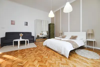 a white bedroom with a bed and a couch at Old Town Sarego Apartment in Kraków