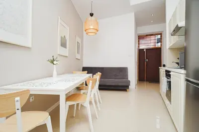 a kitchen and dining room with a white table and chairs at Old Town Sarego Apartment in Kraków