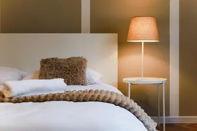 a bedroom with a white bed with a lamp at Old Town Sarego Apartment in Kraków