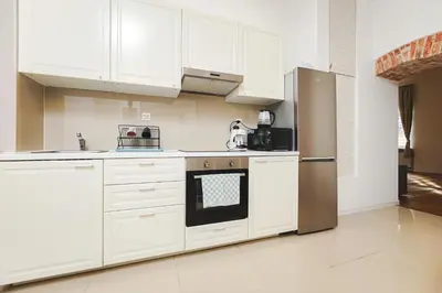 a kitchen with white cabinets and a stainless steel refrigerator at Old Town Sarego Apartment in Kraków