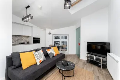 a living room with a couch and a tv at Starowiślna Charming Studio by BookingHost in Kraków