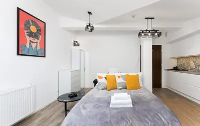 a bedroom with a large bed with yellow pillows at Starowiślna Charming Studio by BookingHost in Kraków