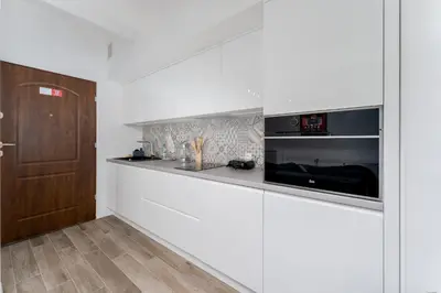 a white kitchen with a counter and a microwave at Starowiślna Charming Studio by BookingHost in Kraków