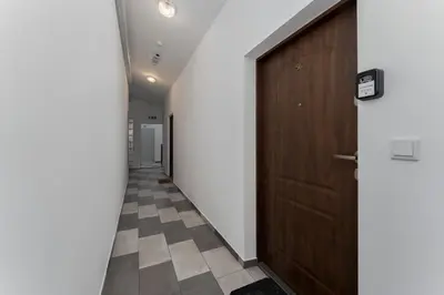 a hallway with a wooden door and a tile floor at Starowiślna Charming Studio by BookingHost in Kraków