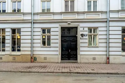 a black door on a white building with windows at Starowiślna Charming Studio by BookingHost in Kraków
