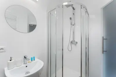 a white bathroom with a sink and a shower at Starowiślna Charming Studio by BookingHost in Kraków