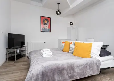 a bedroom with a large bed with yellow pillows at Starowiślna Charming Studio by BookingHost in Kraków