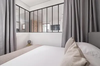 a bedroom with a bed and a large window at 3-Bedroom apartment in Historic Kazimierz in Kraków