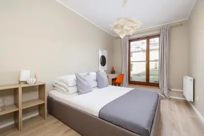 a bedroom with a large bed and a window at 3-Bedroom apartment in Historic Kazimierz in Kraków