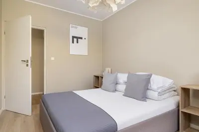 a bedroom with a bed with white sheets and pillows at 3-Bedroom apartment in Historic Kazimierz in Kraków