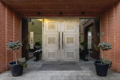a pair of doors in a brick building with potted plants at 3-Bedroom apartment in Historic Kazimierz in Kraków