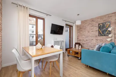 a living room with a table and a blue couch at 3-Bedroom apartment in Historic Kazimierz in Kraków