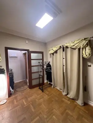 a room with curtains in a room with a wooden floor at 5 min from city center by feet in Kraków