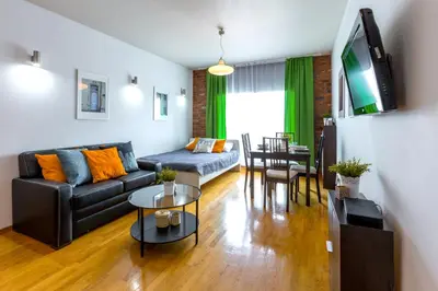 a living room with a couch and a table at Friendhouse Apartments Angel City in Kraków