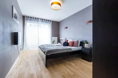 a bedroom with a bed and a large window at Friendhouse Apartments Angel City in Kraków