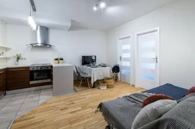 a living room with a kitchen and a dining room at Friendhouse Apartments Angel City in Kraków