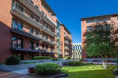 an apartment building with a yard in front of it at Friendhouse Apartments Angel City in Kraków