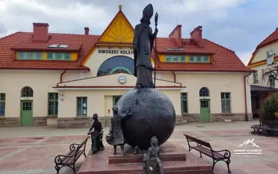 a statue of a woman standing in front of a building at Apartament in Rabka