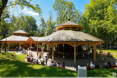 a group of people sitting in a pavilion in a park at Apartament in Rabka