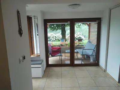 a room with a sliding glass door with a table and chairs at Apartament in Rabka