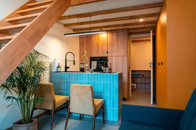 a kitchen with a blue counter and some chairs at Cozy studio in the center of Krakow in Kraków