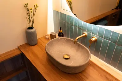 a bathroom with a stone sink on a wooden counter at Cozy studio in the center of Krakow in Kraków