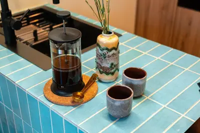 a counter with three cups and a vase on it at Cozy studio in the center of Krakow in Kraków