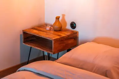 a table with a vase on it next to a bed at Cozy studio in the center of Krakow in Kraków