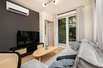 a living room with a couch and a tv and a table at Urban Retreat - Krowoderska Apartment - by Upstairs in Kraków