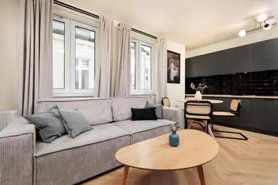 a living room with a couch and a table at Urban Retreat - Krowoderska Apartment - by Upstairs in Kraków