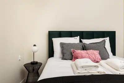 a bed with a green headboard and pillows at Urban Retreat - Krowoderska Apartment - by Upstairs in Kraków