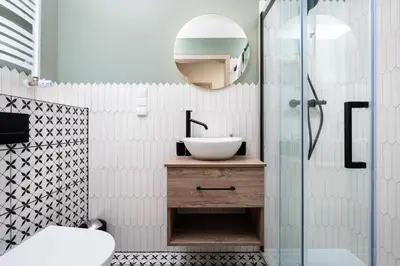 a bathroom with a sink and a glass shower at Urban Retreat - Krowoderska Apartment - by Upstairs in Kraków