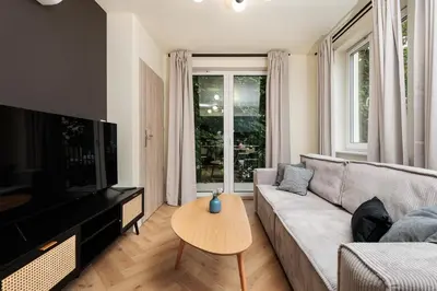 a living room with a couch and a table at Urban Retreat - Krowoderska Apartment - by Upstairs in Kraków