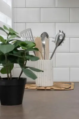 a kitchen counter with a plant and a container of utensils at Komfortowy Apartament z Klimatyzacją by Noclegi Renters in Kraków