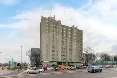 a large building with cars parked in a parking lot at Komfortowy Apartament z Klimatyzacją by Noclegi Renters in Kraków