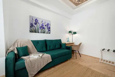 a living room with a green couch and a table at Komfortowy Apartament z Klimatyzacją by Noclegi Renters in Kraków