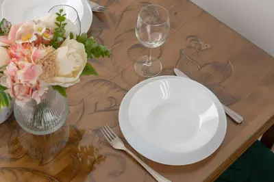 a table with a white plate and a vase of flowers at Komfortowy Apartament z Klimatyzacją by Noclegi Renters in Kraków