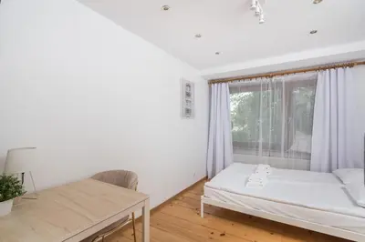 a white bedroom with a bed and a window at Old Town Loft - 7 Bedroom Apartment - by Upstairs in Kraków