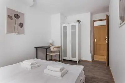 a bedroom with a bed with white sheets and a desk at Old Town Loft - 7 Bedroom Apartment - by Upstairs in Kraków