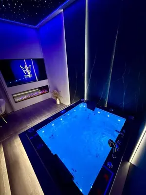a swimming pool in a room with blue lighting at Starowiślna Prestige VIP Apartamenty Jacuzzi in Kraków