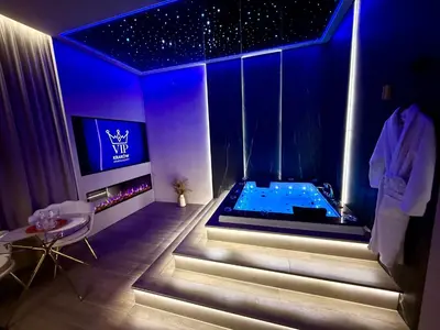 a bathroom with a tub in a room with blue lighting at Starowiślna Prestige VIP Apartamenty Jacuzzi in Kraków