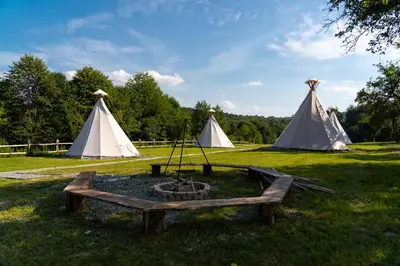 a group of tents with a fire pit in the grass at Moon Glamping