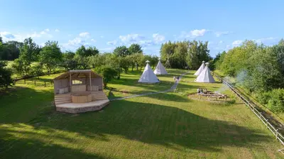 a group of tents in a field with trees at Moon Glamping