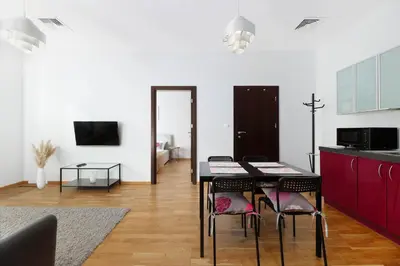 a kitchen and dining room with a table and chairs at plac Na Groblach 5 by Homeprime in Kraków
