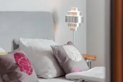 a group of pillows sitting on a bed with a lamp at plac Na Groblach 5 by Homeprime in Kraków